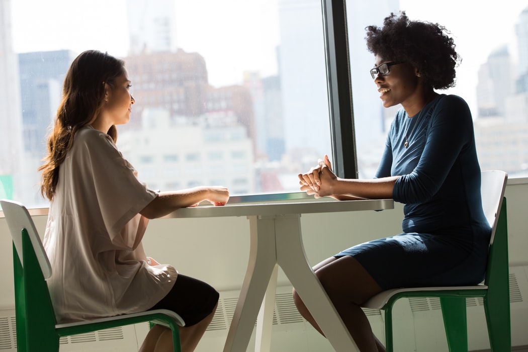 2 women talking at a table