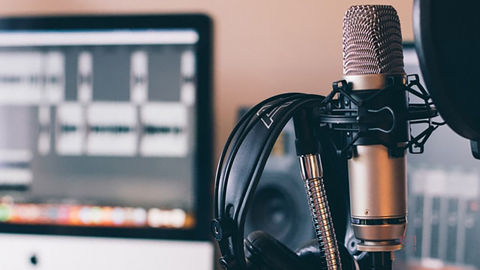 Image of microphone and headsets with a computer in the background
