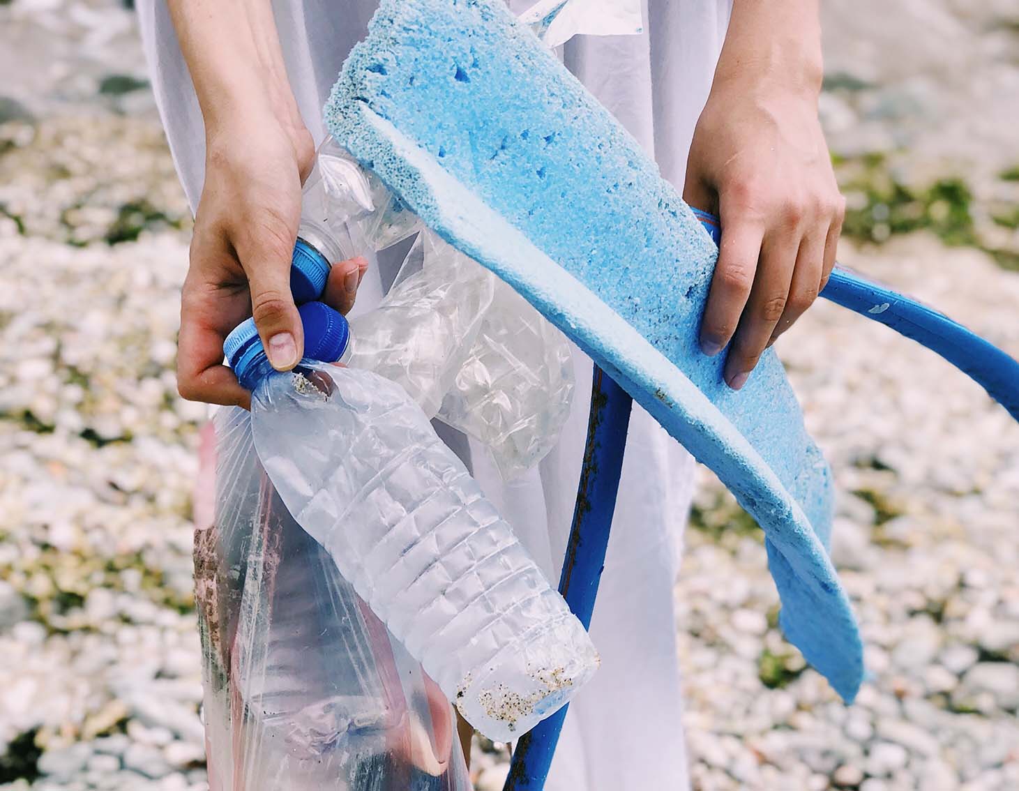 Stock image of a woman holding a water bottle & rubbish