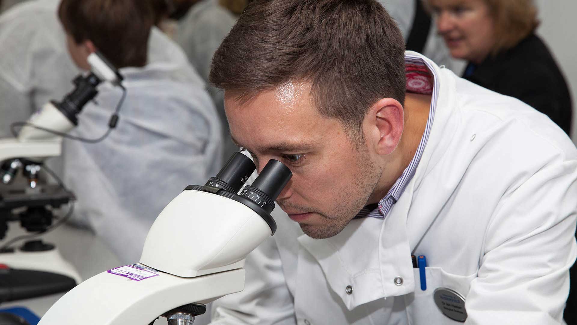 Scientist looking through microscope