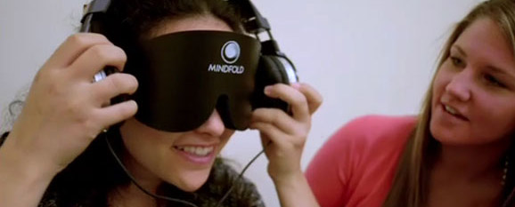 A couple of young ladies looking at a video game with excitement, one with 3D googles on.